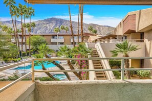A hotel with a pool, palm trees, and a mountainous backdrop. - Atomic Starburst – Mountain View Downtown Condo (Palm Springs)