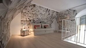 Ein Schlafzimmer mit einem weißen Sofa, roten Kissen und einer Zierte Decke.