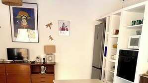 Een moderne keuken met een centraal eiland, een houten barstoel en een schaal fruit.