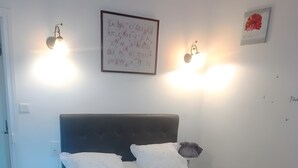 A neatly arranged bedroom with a bed, bedside tables, and wall-mounted lighting. - Bed and Breakfast 'Mas De Maussan' with Mountain View, Wi-Fi and Air Conditioning (Robion)