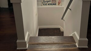 Un escalier avec des rampes blanches menant à un palier.