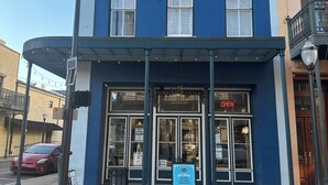 Un bâtiment à deux étages, doté d’une façade bleue, de grandes fenêtres et d’un espace d’entrée abrité.
