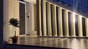 Een modern gebouw met een trap naar een hoger niveau, een potplant en een aantal verticale lampen.