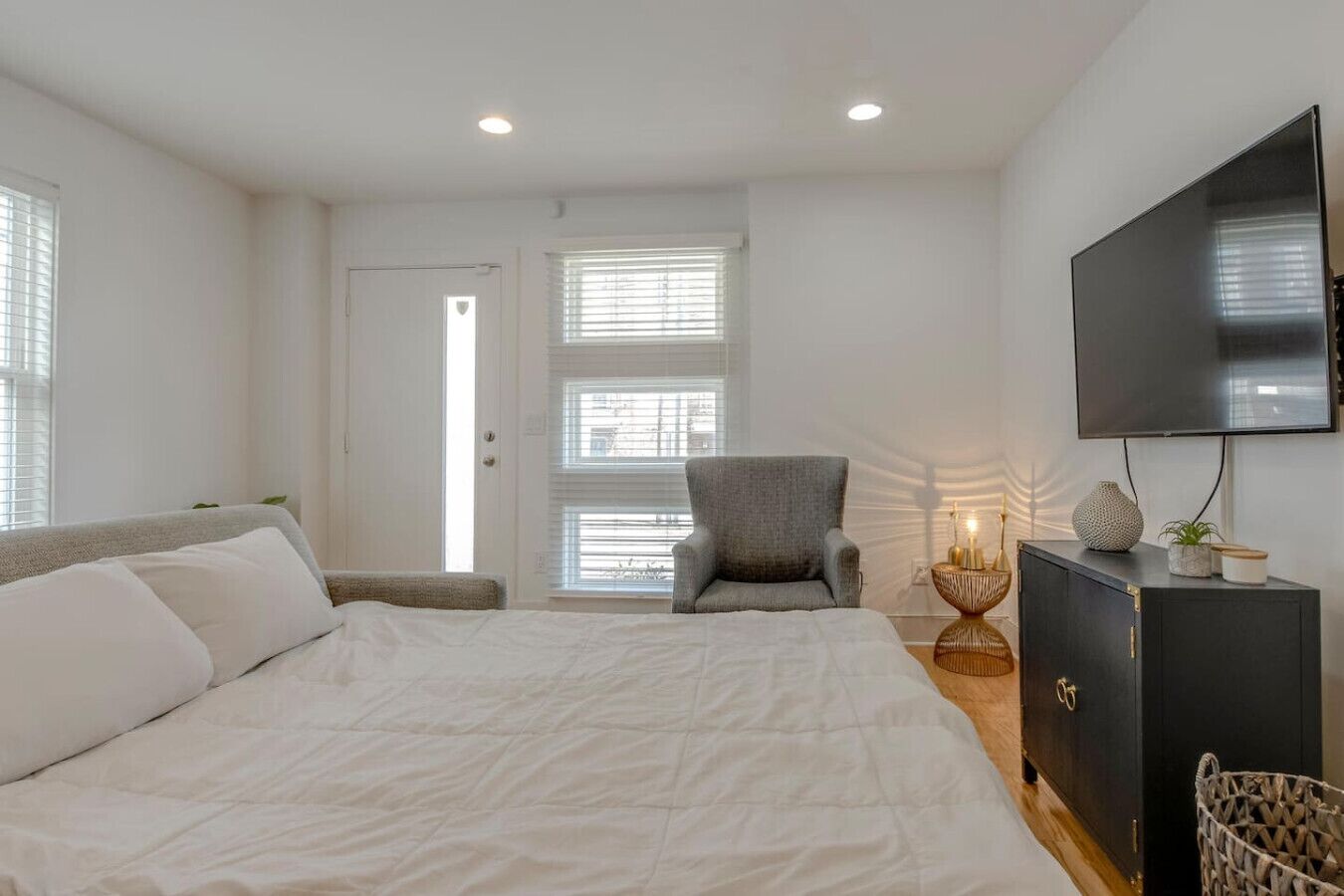 A bedroom with a bed, a chair, a TV, and a cabinet.