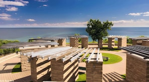 A coastal resort with outdoor seating areas, stone structures, and a view of the sea. - Modern 4‑Bedroom Retreat I 2‑Car Parking I Steps from the Ajax Waterfront (Ajax)