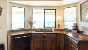 A kitchen with a built-in dishwasher, a double sink, and a window providing a view of the outdoors.