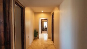 A hallway with a tiled floor and wooden doors.