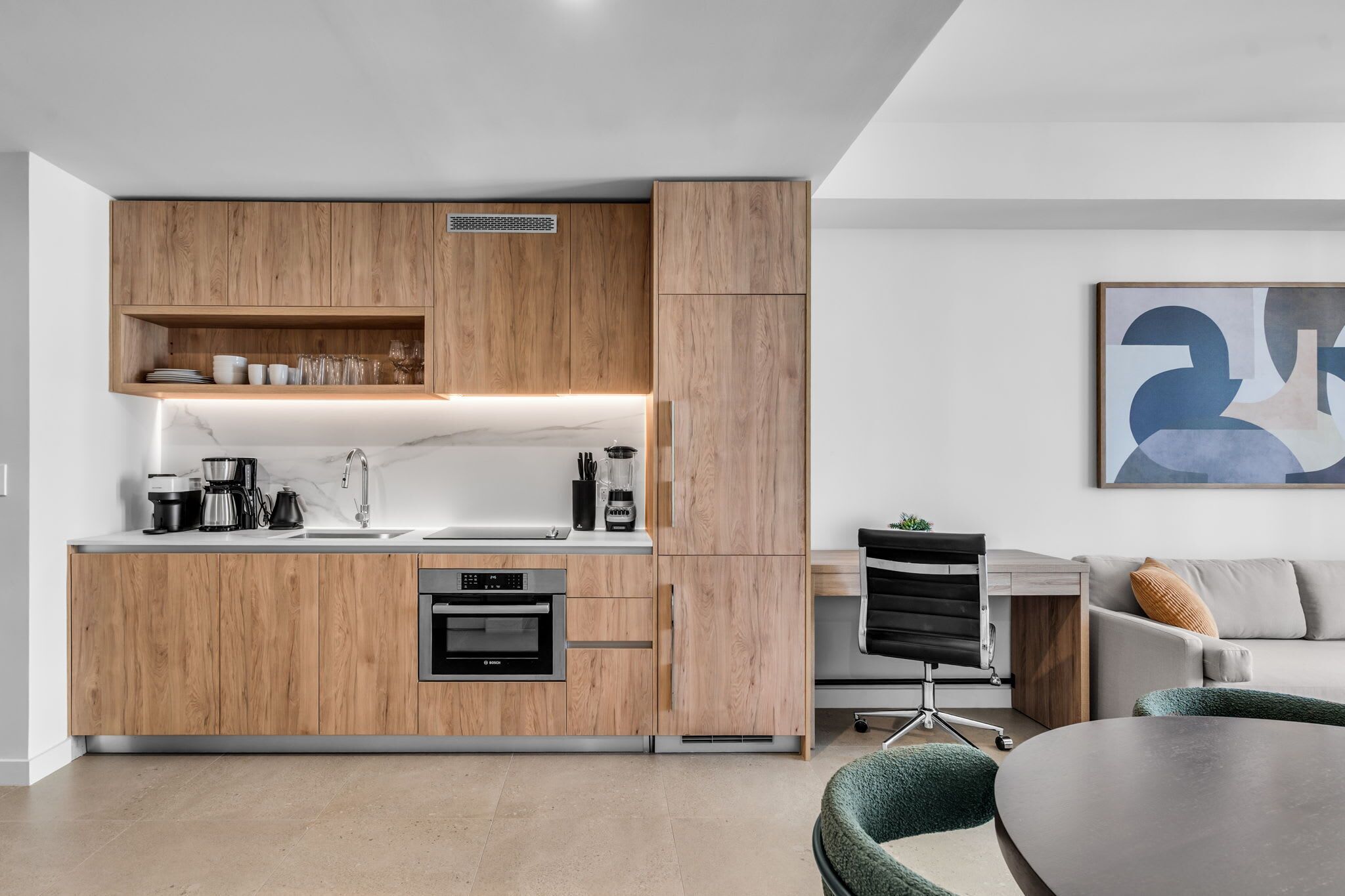 Une cuisine moderne avec des meubles en bois, un four encastré et un coin café.