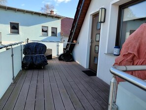 A wooden deck with a covered grill and a door. - NEW! Modern apartment Koi 2 OG Usedom (Zirchow)