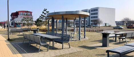 An outdoor seating area with benches and a central gazebo.