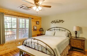A bedroom with a bed, bedside tables, a ceiling fan, and a window with curtains. - Sheffield Lake Lodge @ Sinclair (Sparta)