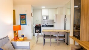 A compact living space with a kitchenette, a dining area, and a seating area with a sofa and a table. - Buenos Ayres #509 - Apt With Balcony by Carpediem (João Pessoa)