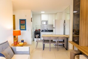 A compact living space with a kitchenette, a dining area, and a seating area with a sofa and a table. - Buenos Ayres #509 - Apt With Balcony by Carpediem (João Pessoa)