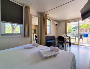 Habitación de hotel con una cama, un escritorio y vistas al exterior.