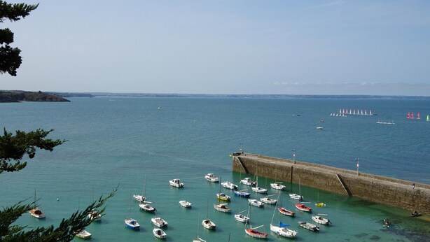 A harbor with numerous small boats docked near a stone pier. - Cosy House Just Steps Away From the sea (Lamballe-Armor)