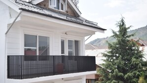 A white building with a black balcony, a window, and a tree. - Everglow Retreat White Tulip Guest House (Srinagar)