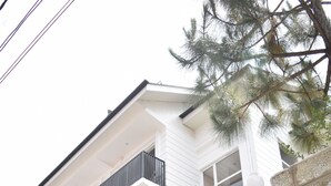 A multi-story house with a balcony, a garage, and a tiled driveway. - Everglow Retreat White Tulip Guest House (Srinagar)