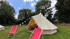A tent with a sleeping area and a red chair. - Dovedale (Ashbourne)