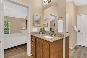A bathroom with a granite countertop, wooden cabinets, a sink, and a large mirror. - Yosemite Nature Escape: Pvt Gem • Pets • BBQ • Cozy • Split BRs (Mariposa)