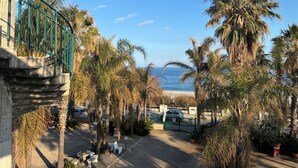 A paved pathway lined with palm trees and a view of the sea. - Apartment 'I Ciottoli Dello Ionio - Apt 10' with Sea View, Shared Terrace and Balcony (Mascali)