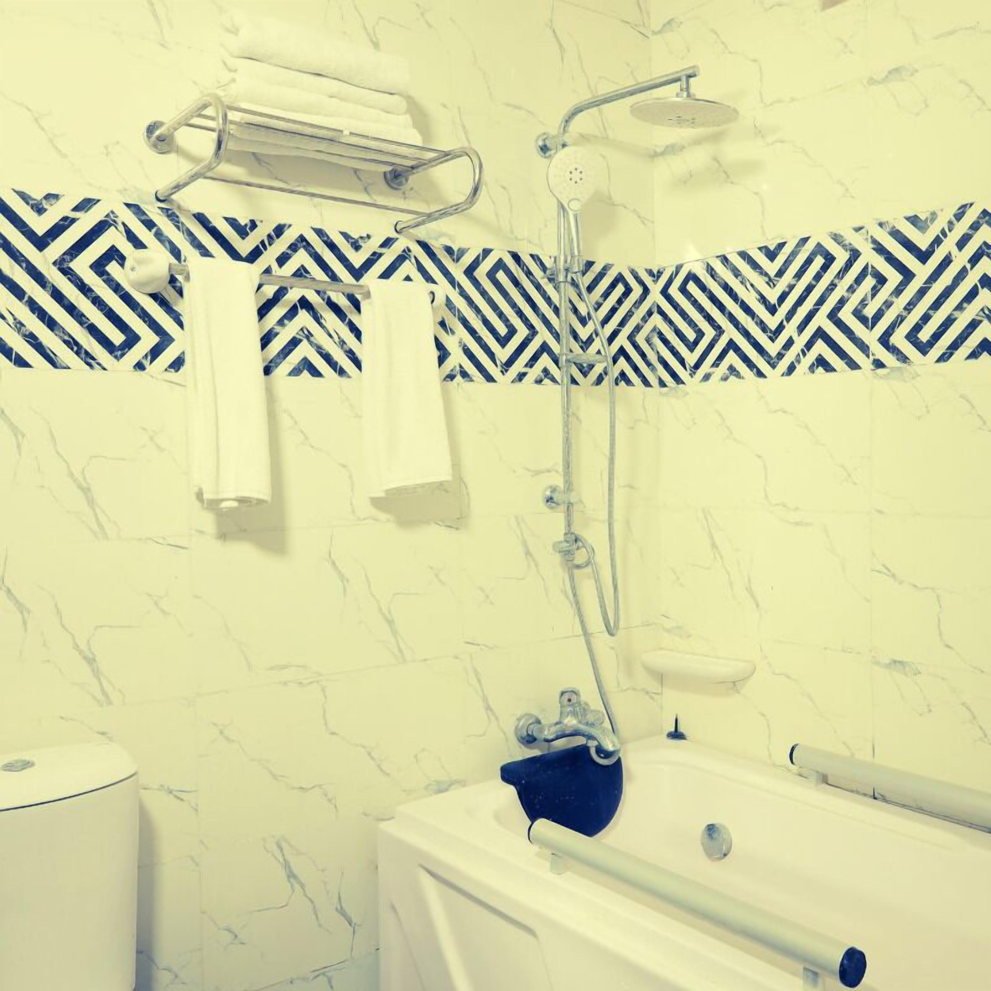Ein Badezimmer mit Dusche, Badewanne und Handtuchhalter.