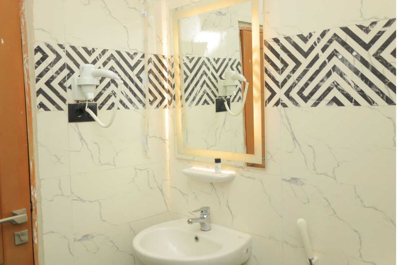 A bathroom with a white sink, a mirror, and a towel rack.