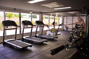 Ein Fitnessraum mit Laufbändern, Crosstrainern und Krafttrainingsgeräten.