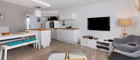 A modern apartment with a kitchen, dining area, and living space.