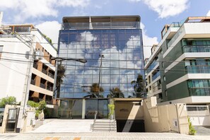 A modern building with a glass facade reflecting clouds, a staircase leading to the entrance, and a visible 'SETA EDITION' sign. - Setai Edition #113 - Seaside by Carpediem (João Pessoa)