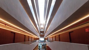 A modern hotel corridor with a central walkway, flanked by rooms with wooden paneling and a glass railing. - Setai Yacht #522 - Beira mar by Carpediem (João Pessoa)