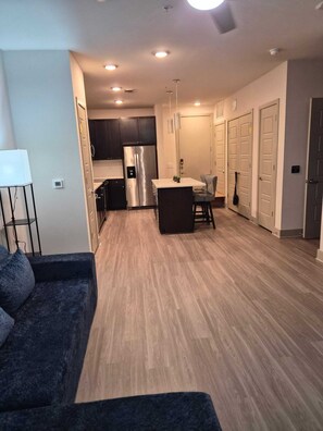 A modern apartment with a kitchen, dining area, and living room. - Luxury 2 bedroom with two baths Pool Gym (Frisco)