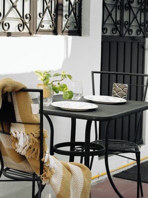 Une table à manger avec des chaises, une plante et un verre.
