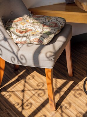 Une chaise dotée d’un coussin à motifs, de pieds en bois et d’un siège en tissu.