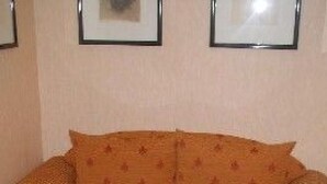 Ett vardagsrum med en soffa och ett soffbord i glas.
