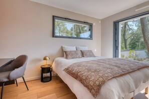 Une chambre à coucher avec un lit, une chaise, une lampe et une fenêtre.