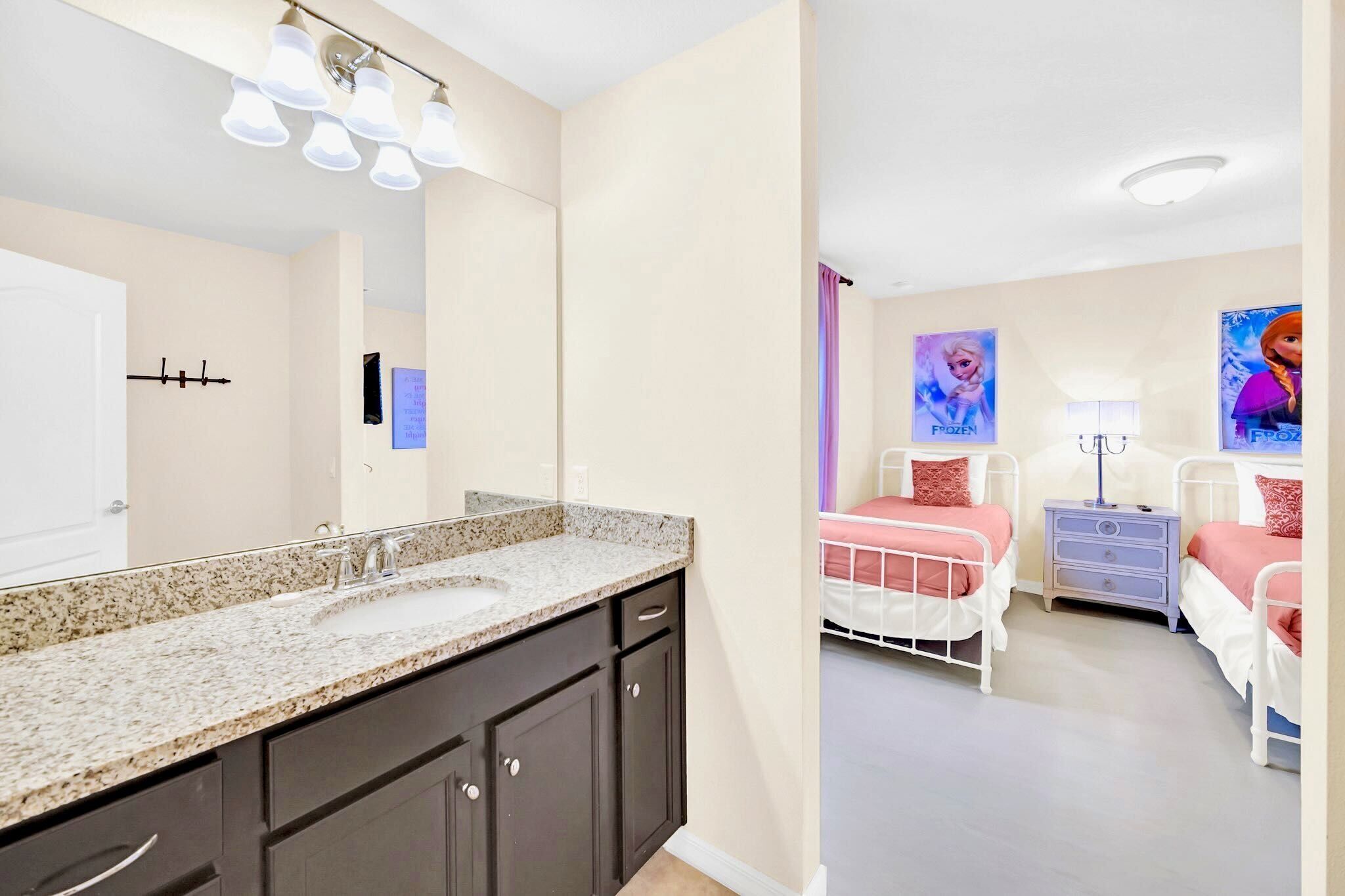 A modern bathroom with a granite countertop sink and dark cabinetry.