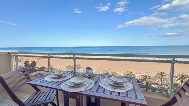 Ett dukat bord för middag med utsikt över stranden och havet.