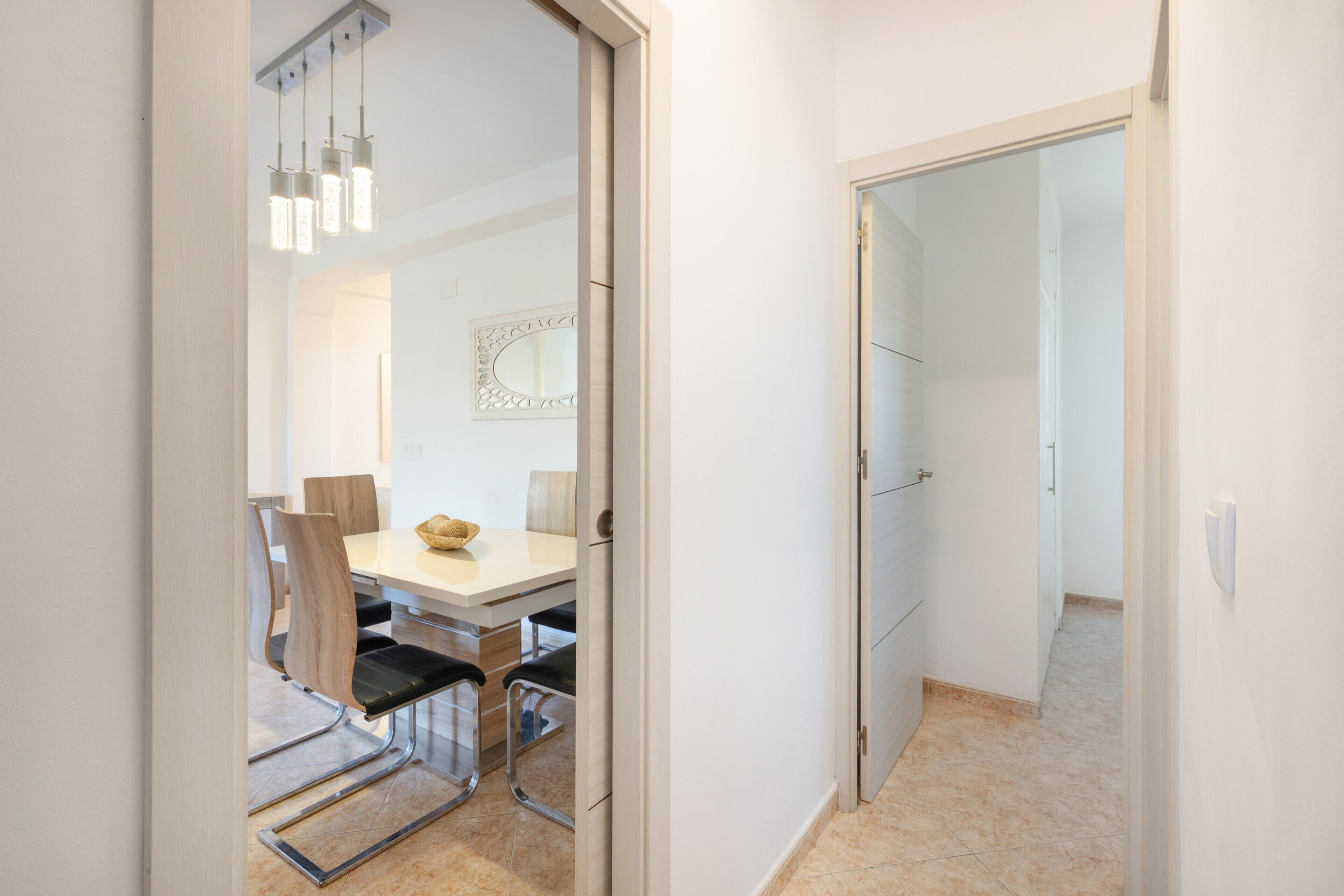 Een moderne eethoek met een tafel, stoelen en hanglampen.