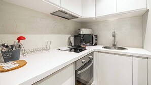 Eine moderne Küche mit weißen Schränken, einer Mikrowelle, einem Toaster und einem Spülbecken.