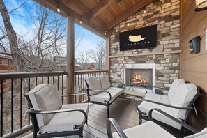 A covered outdoor seating area with stone walls, a fireplace, and a sign for Magnolia. - Indoor Pool • Game Room • 1 Mile to Strip (Pigeon Forge)