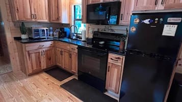 Coffee/tea maker, fridge, paper towels, dining table