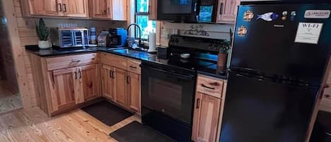 Coffee/tea maker, fridge, paper towels, dining table