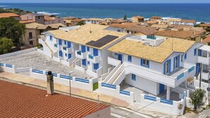 Zona residencial costera con edificios blancos, detalles azules y vista al mar.
