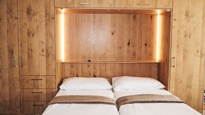 Ein Zimmer mit Holzwandverkleidung, einem Bett und einem Einbauschrank.