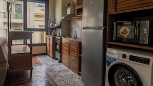 A compact kitchen with a built-in oven, microwave, and washing machine. - Taylor's Port [3] Landing in the Old Town (Montevideo)