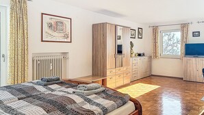 Een slaapkamer met een groot bed, een houten garderobe en een radiator.