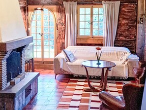 A cozy room with a fireplace, a sofa, a small table with a vase, and a checkered floor.