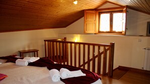 A bedroom with a wooden ceiling, a bed with white linens, a red throw blanket, and a window with curtains. - Studio with Kitchenette (Sleeps 4) (Rabal)