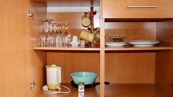 A kitchen with wooden cabinets, a coffee maker, a tea kettle, a blue bowl, and a wine rack.