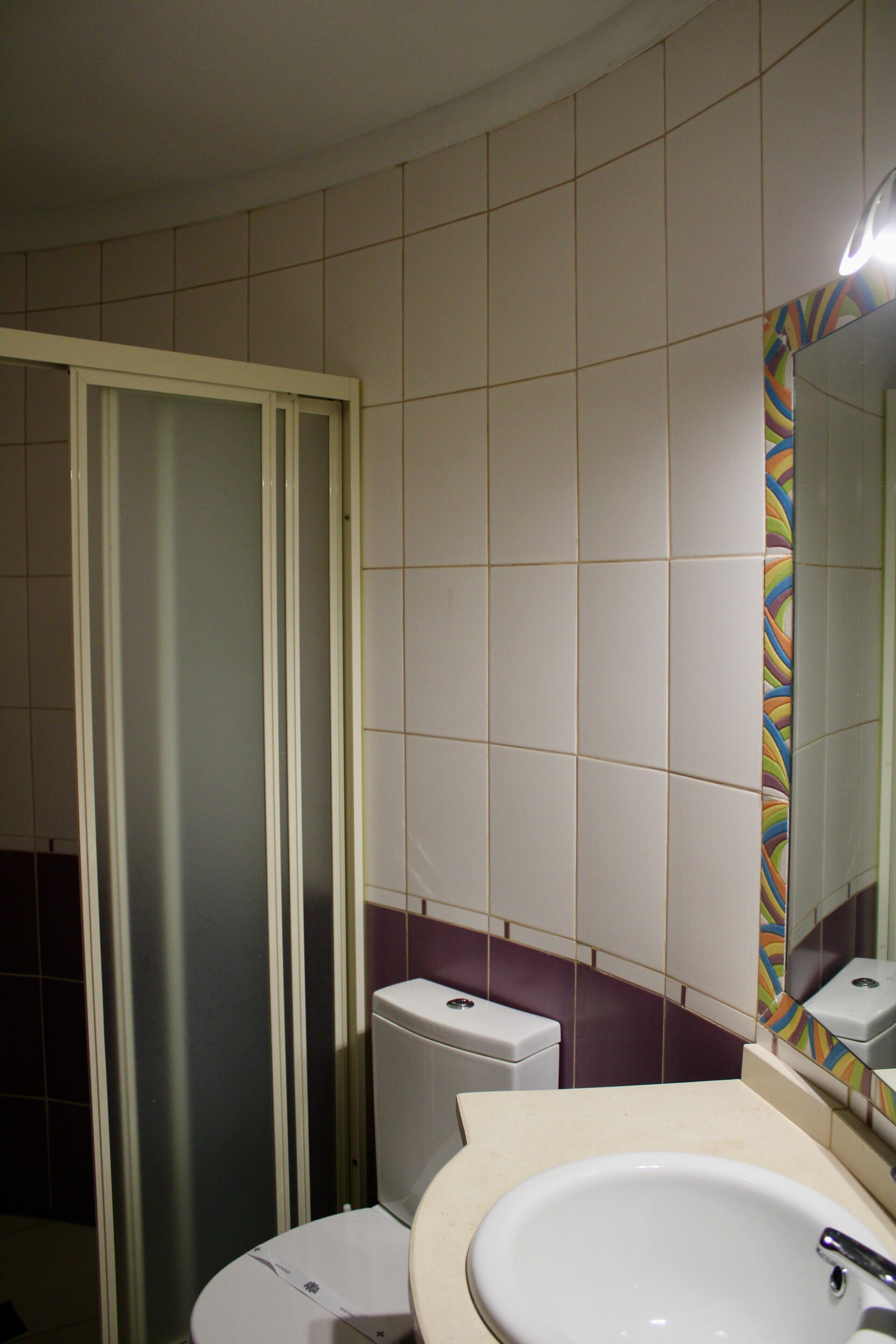 A bathroom with a toilet, a sink, and a shower stall.